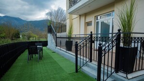 A balcony with artificial grass, a dining table, chairs, and a black metal railing. - Spacious_Home_Kleitoria (Kleitoria)