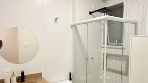 A modern bathroom with a glass-enclosed shower, a white sink, and a toilet. - Loft Copa Charm (Rio de Janeiro)