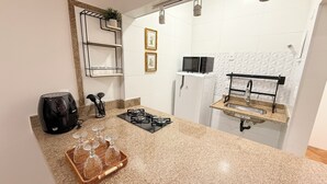 A modern kitchen with granite countertops, a built-in microwave, a gas stove, and a sink with a towel rack. - Loft Copa Charm (Rio de Janeiro)