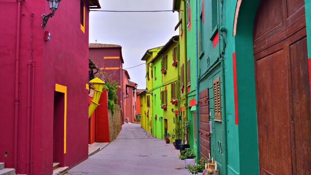 Une rue étroite bordée de bâtiments aux couleurs vives.