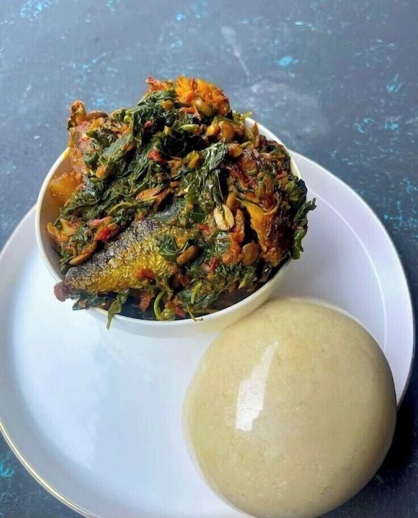 A bowl of fish and greens with a side of fufu. - Daveange Hotels (Port Harcourt)