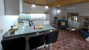 A modern kitchen with a central island, bar stools, and pendant lighting.