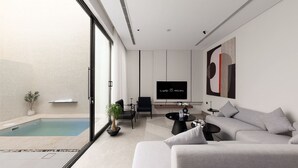 A modern living room with a pool, a grey sofa, a TV, and a minimalist design. - Nolina chalets (Madinah)