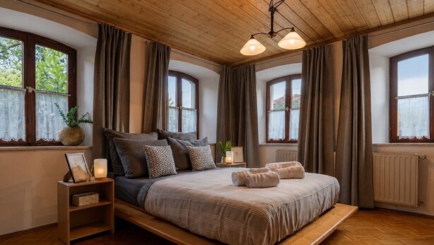 Ein Schlafzimmer mit einem Bettgestell aus Holz, einem Nachttisch und einem Fenster mit Vorhängen.