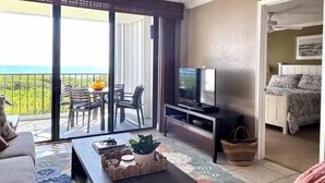 A living room with a balcony, a television, and a sofa.