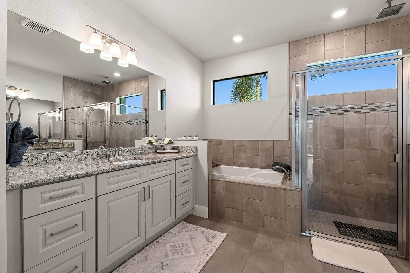 A modern bathroom with a large vanity, a walk-in shower, and a bathtub.