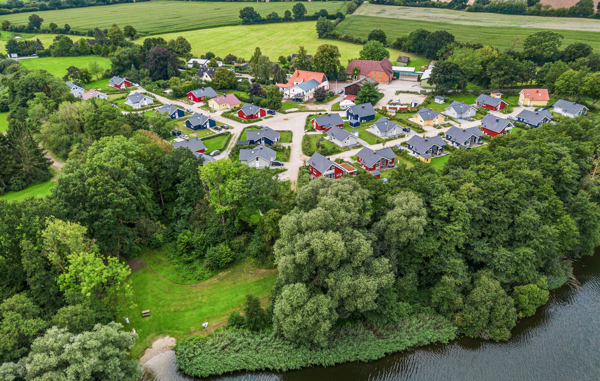 An aerial view of a residential area with houses arranged in a semi-circular pattern around a central green space, likely a park or garden.