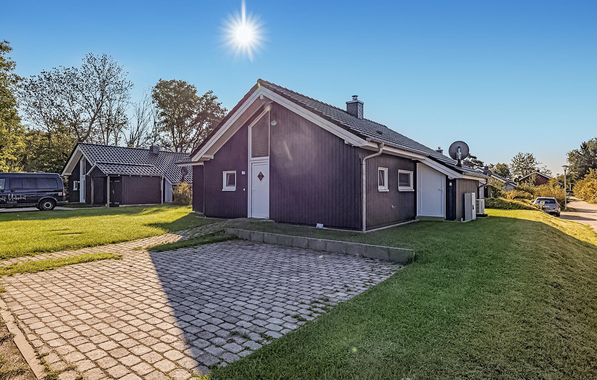 A modern two-story house with a paved driveway and a well-maintained lawn.
