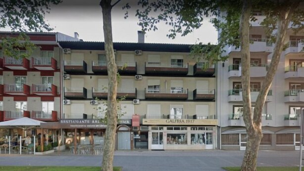 Un hôtel à plusieurs étages doté de balcons, d’un restaurant et d’une boutique.