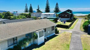 Área residencial com casas, um caminho e vista para o oceano.