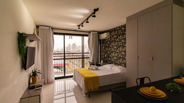 A modern bedroom with a bed, a desk, and a dining area.