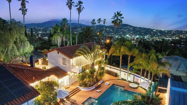 A residential property with a swimming pool, outdoor seating, and a view of a cityscape at dusk. - Luxury 5BR Villa - Pool, Spa, Movie Theater, Game Room, Bar, & Outdoor Dining (La Mesa)