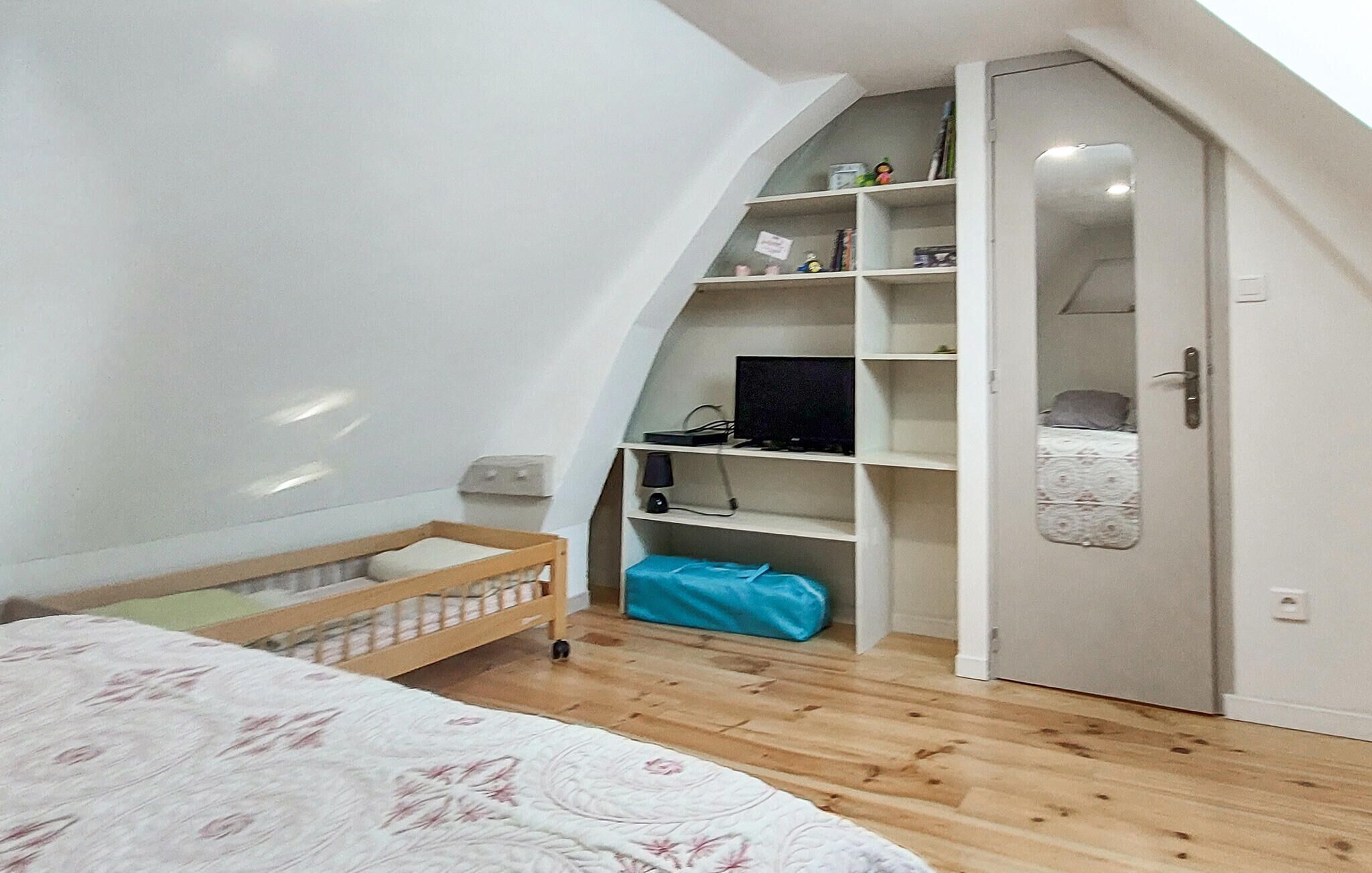 Ein Schlafzimmer mit einem Bett, einem Kleiderschrank und einem Schreibtisch mit Computer.