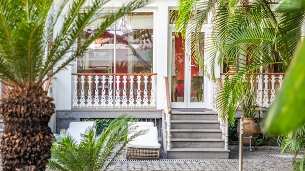 A building with a white facade, a balcony with white railings, and a staircase leading to the entrance. - XIX Writer’s Belle Époque Villa • Central Funchal • Tropical Garden • BBQ (Funchal)