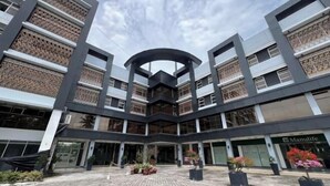 A modern building with a central atrium, multiple floors, and a Manulife store. - Dreamweavers Hotel by RedDoorz (Koronadal City)