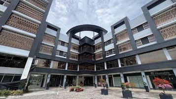 Un edificio moderno con un atrio central, varios pisos y una tienda Manufuge.