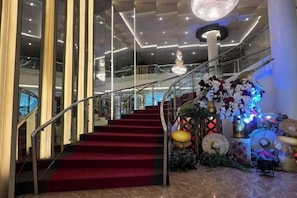 A grand staircase with a red carpet, leading to a balcony with a glass railing. - Dreamweavers Hotel by RedDoorz (Koronadal City)