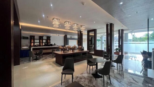 A modern interior with a bar area, seating, and a large window providing a view. - Dreamweavers Hotel by RedDoorz (Koronadal City)