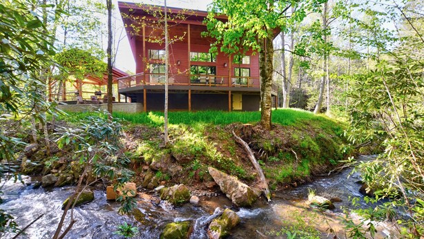A cabin with a wooden deck and a view of a stream. - Rushing Waters Cabin (Sylva)