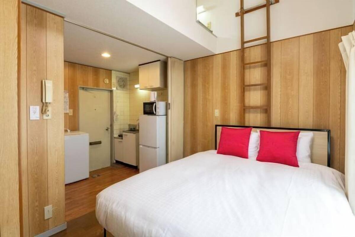 Une chambre d’hôtel comprenant un lit, une armoire, une kitchenette et une salle de bain.