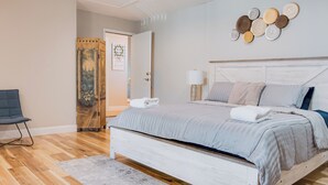 A bedroom with a bed, a chair, a door, and a wall decoration. - Magic Retreat Orlando (Davenport)