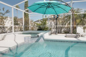 A swimming pool with a turquoise umbrella, white tiled steps, and a white lounge chair. - Magic Retreat Orlando (Davenport)