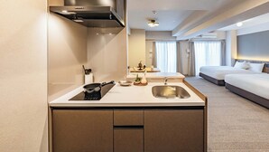 Una habitación de hotel moderna con kitchenette, cama y baño.