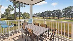 A covered patio with a table and chairs, overlooking a golf course. - Relax at Magnolia Pointe — Minutes from the Beah | Magnolia Pointe Luster Leaf 4882-202 (Myrtle Beach)