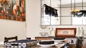 A dining area with a table set for four, a framed certificate on the wall, and a chandelier. - Charming Historic Retreat in Old Town St. Charles (Saint Charles)