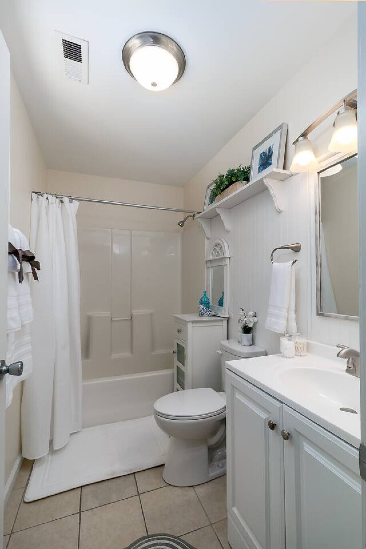 Une salle de bain équipée d’une douche, de toilettes, d’un lavabo et d’un miroir.