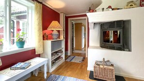 A cozy living room with a fireplace, a bookshelf, a table, and a window with curtains. - 2 bedroom awesome home in Arboga (Arboga)