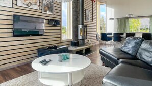 Un salon moderne doté d’une cheminée, d’un téléviseur à écran plat, d’un canapé en cuir et d’une table basse ronde.