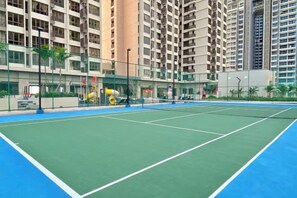 Una cancha de tenis rodeada de edificios residenciales altos.