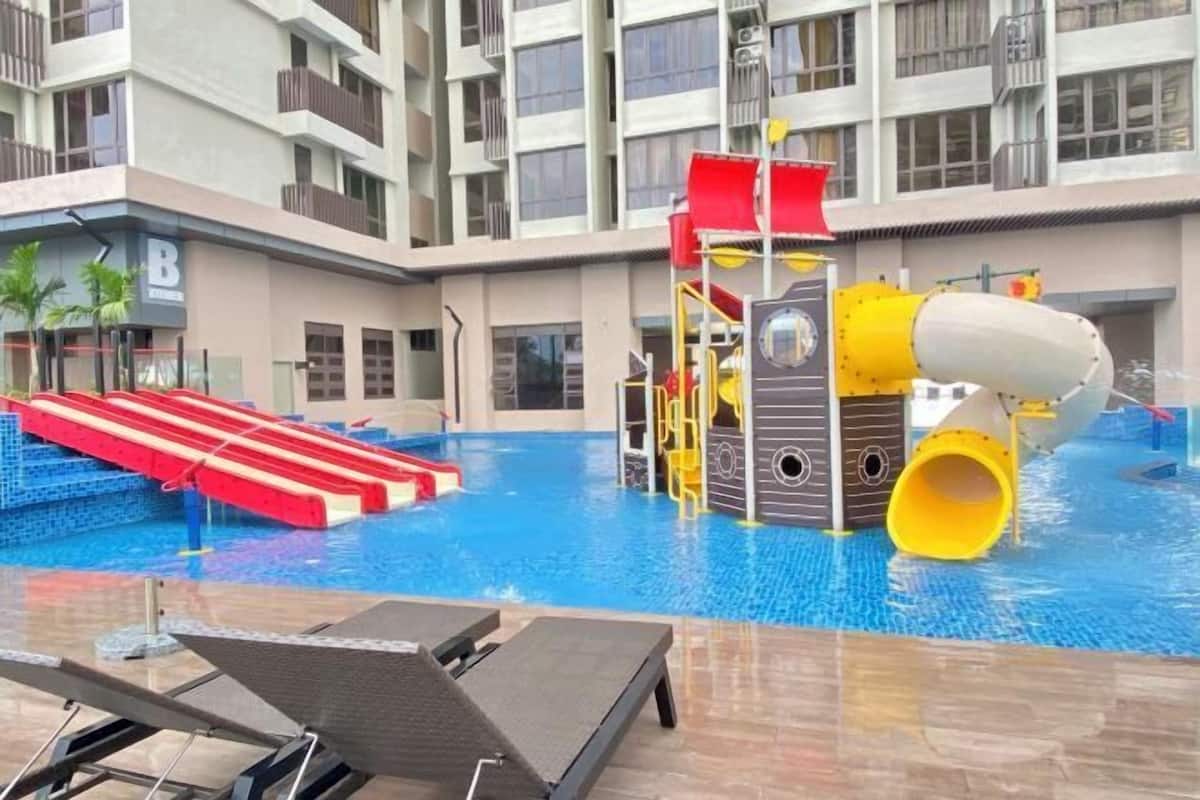An indoor swimming pool with slides and water play structures.