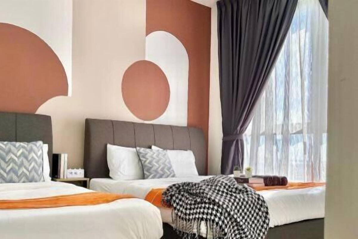 A hotel room with two beds, a large window with curtains, and a modern wall design.