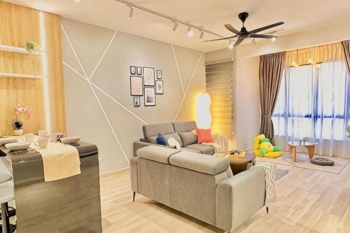 A modern living room with a sofa, a dining area, and a ceiling fan.