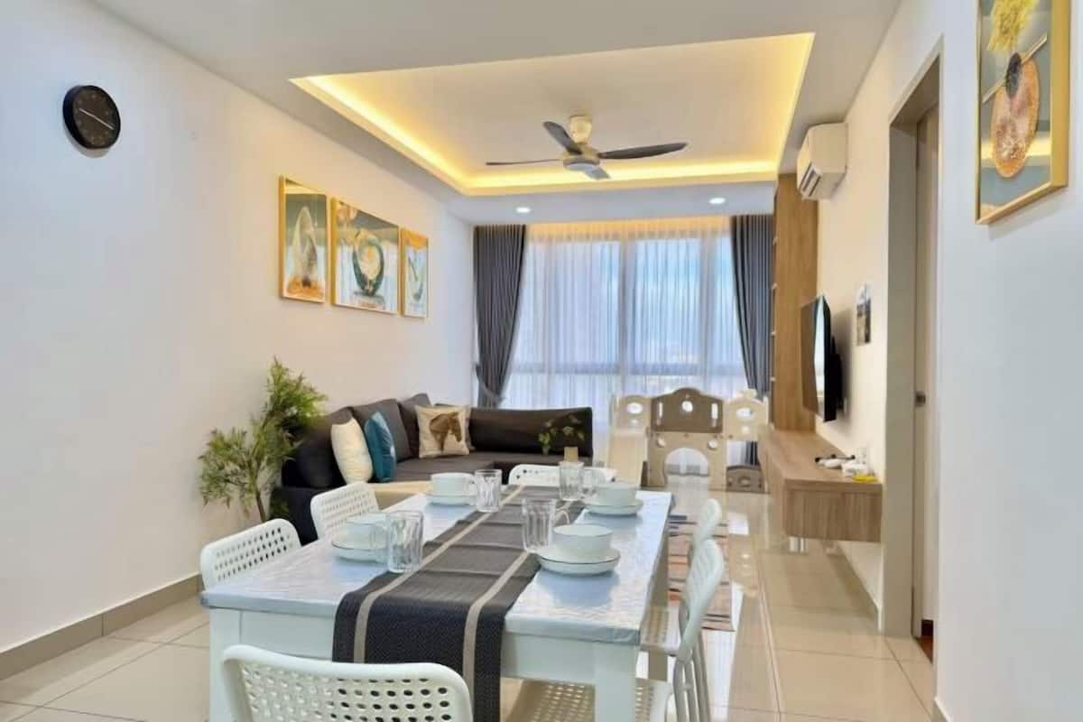 A modern living room with a dining area, a ceiling fan, and artwork on the walls.