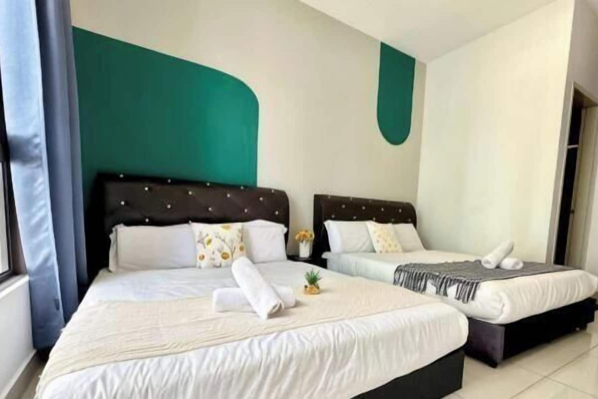 A hotel room with two beds, a teal accent wall, and a large window.