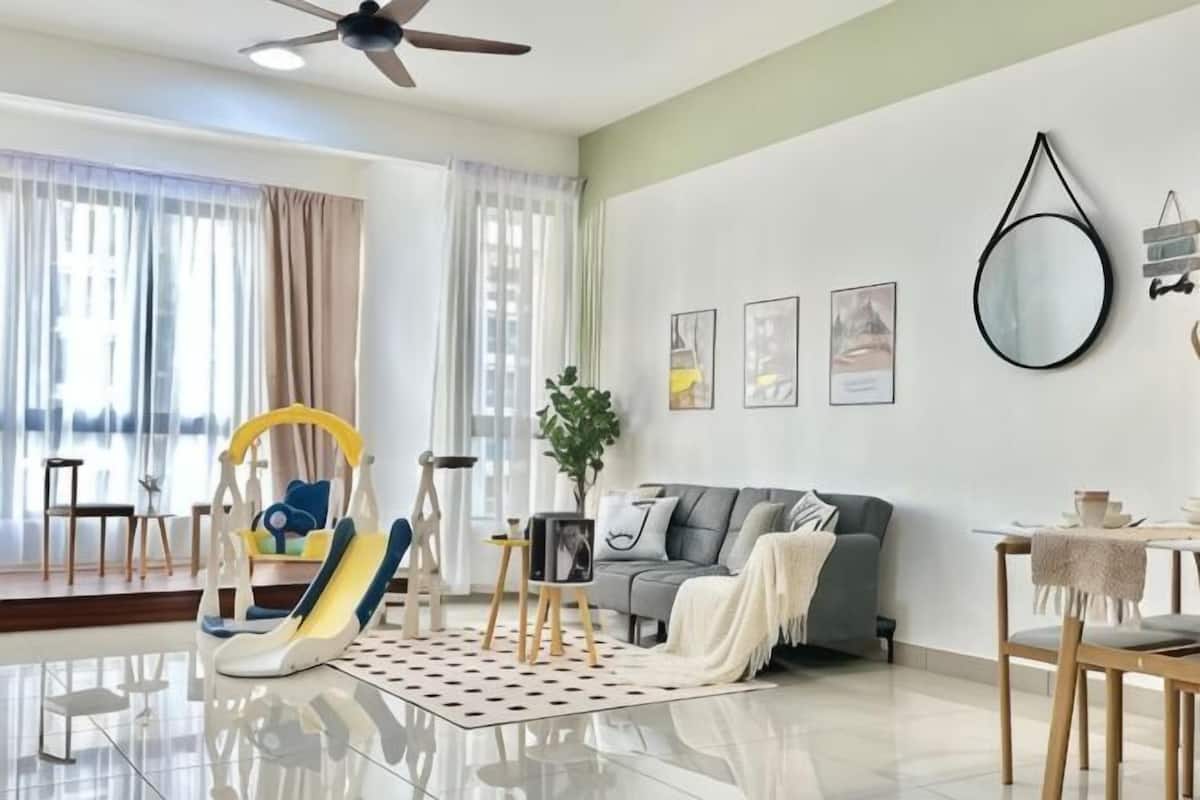 Un salon moderne avec un canapé, une table à manger, un ventilateur de plafond et une grande fenêtre avec des rideaux.