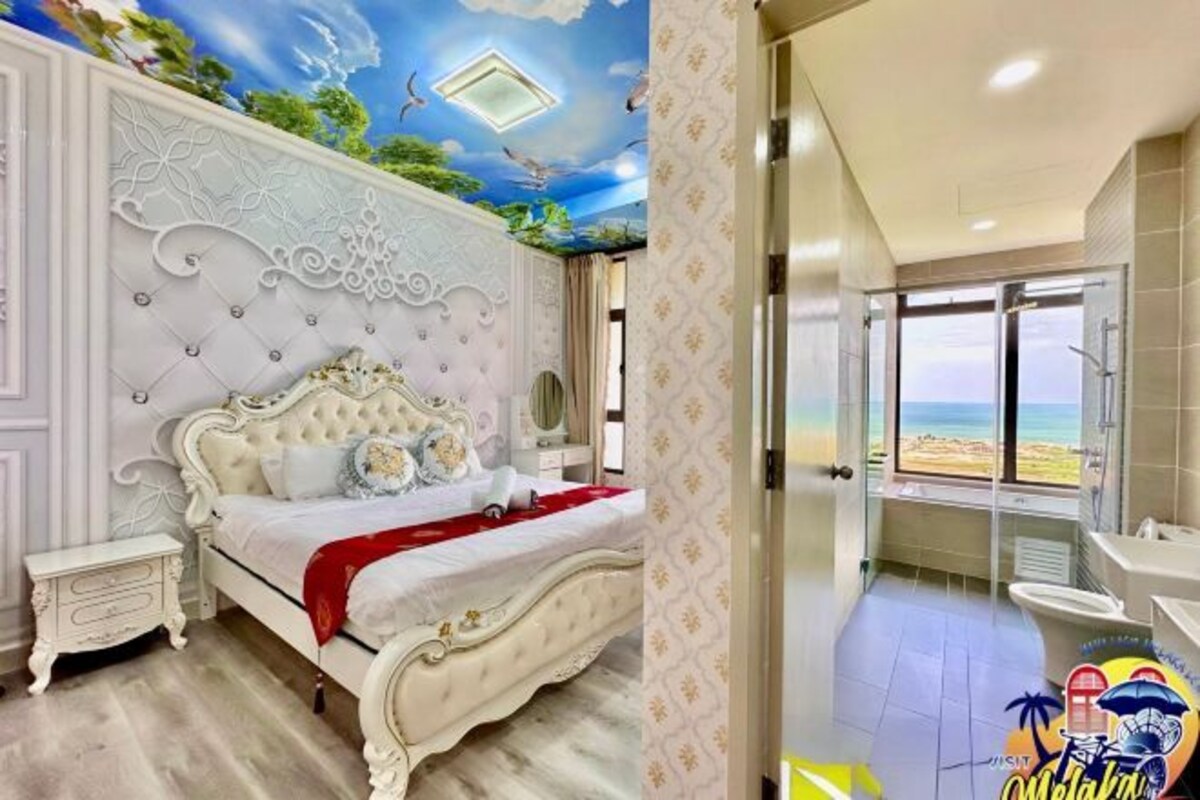 Un dormitorio con cama, un baño con ducha y vistas a la playa.