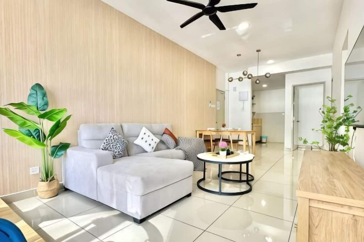 A modern living room with a sofa, coffee table, and plants.