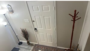 A staircase with a white railing, a door at the top, and a vase with dried plants on the landing. - 3-bedroom townhome in delightful Germantown with AC without basement (Germantown)