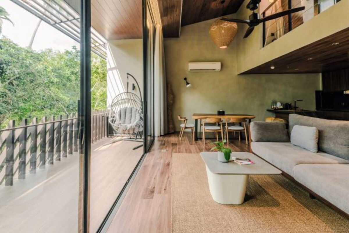 Una sala de estar moderna con sofá, mesa de centro y mesa de comedor.
