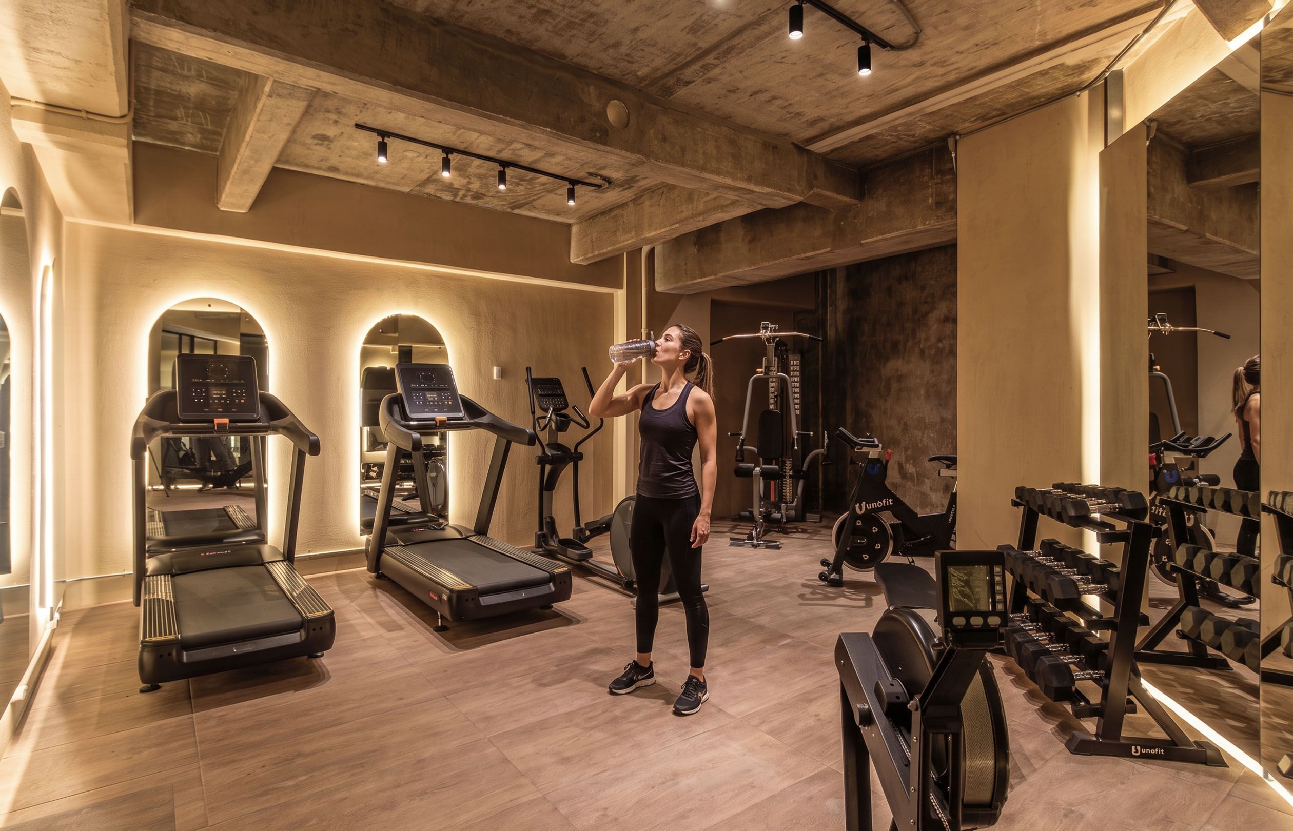 Ein Fitnessstudio mit Laufbändern, Crosstrainern und Gewichtsmaschinen.