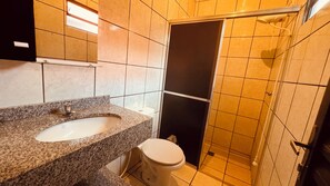 Een douche, handdoeken, zeep, toiletpapier