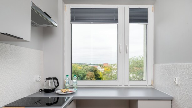 Une cuisine compacte équipée d’une cuisinière, d’une bouilloire et d’une petite table à manger.
