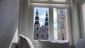 A room with a large window overlooking a historic building with two towers.