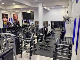 Un gimnasio con diverso equipo de ejercicio, que incluye cintas de correr, máquinas de pesas y pesas libres.