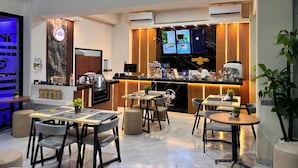 Un comedor moderno con barra, disposición de asientos y pantalla de televisión.
