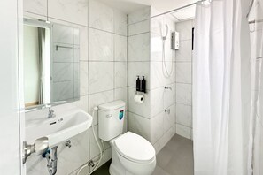 A modern bathroom with a white toilet, a sink, a shower, and a mirror. - i24 Residence - Amata Phase 10 (Phan Thong)
